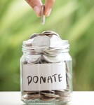 Hand-putting-coins-in-glass-jar-for-giving-and-donation-concept-picture-id813128966