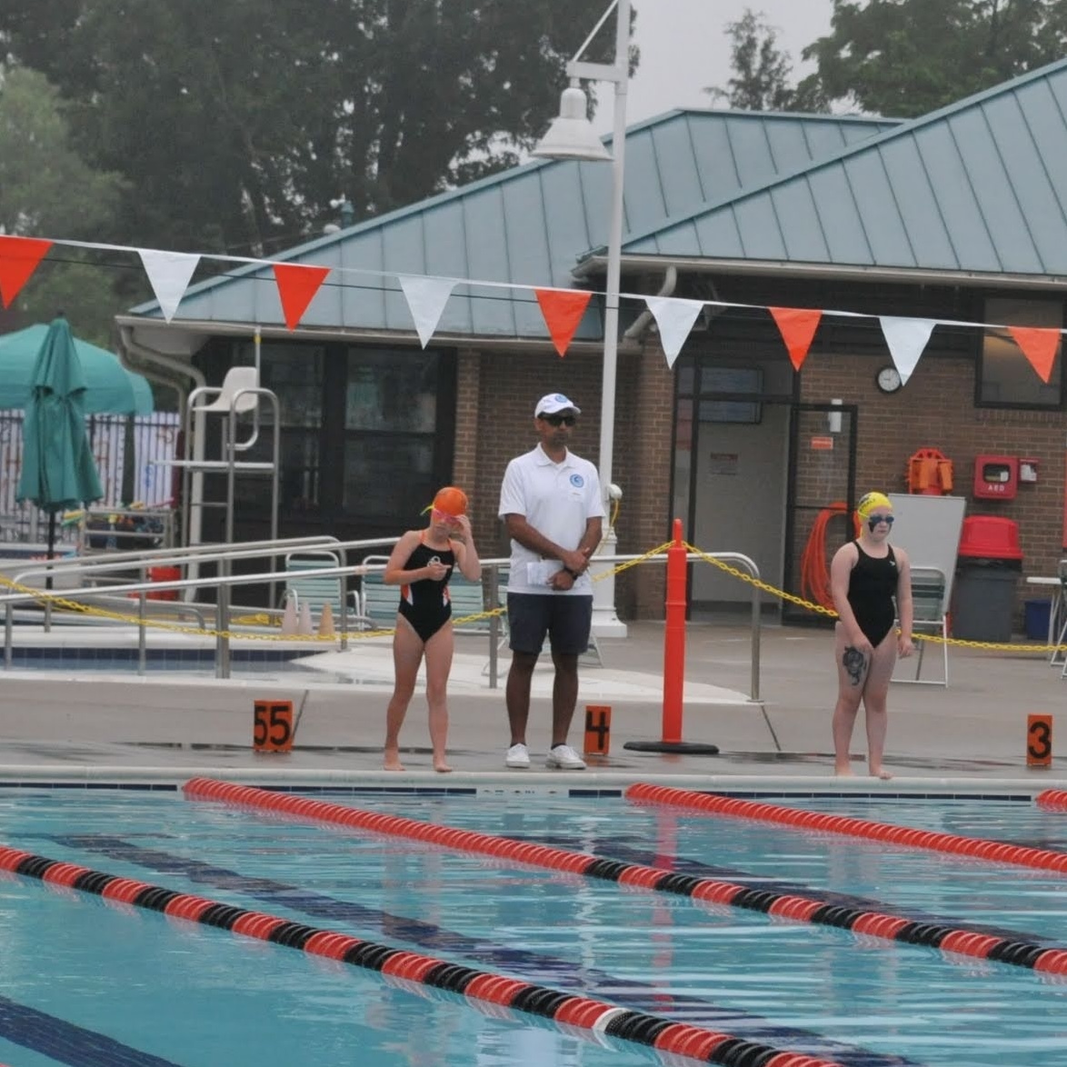 An Overlee Official stands with swimmers at the start of a race