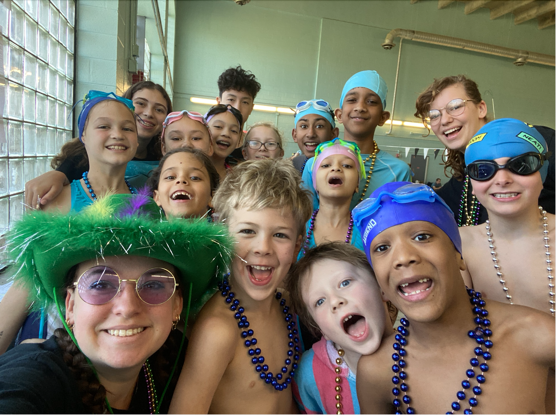 Coach Cara, Coach Lindsey, and Coach Valentina with our excited, smiling dolphins!